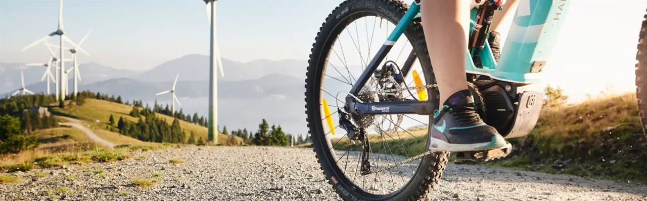 E-Mountainbike am Pretul mit Windrädern im Hintergrund