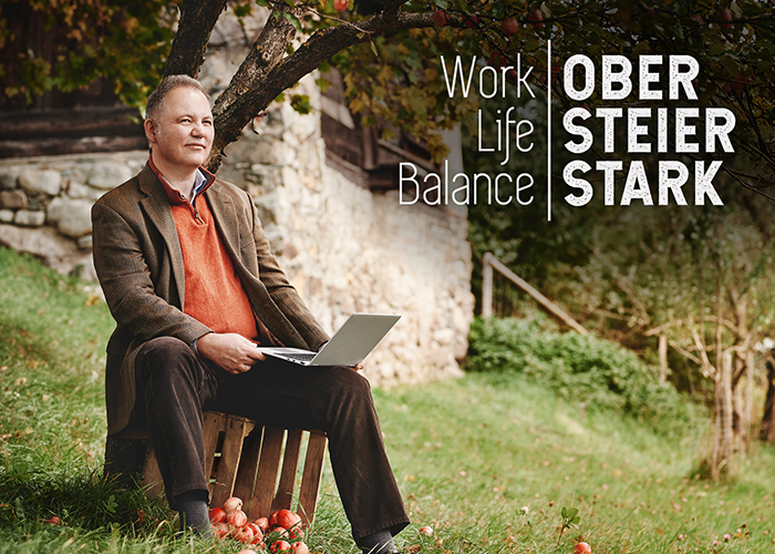 Work Life Balance, Mann mit Laptop im Obstgarten